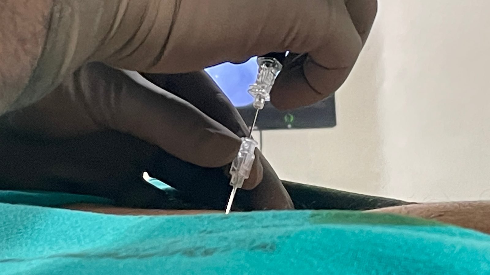 Pain specialist placing a needle for a targeted injection under sterile conditions